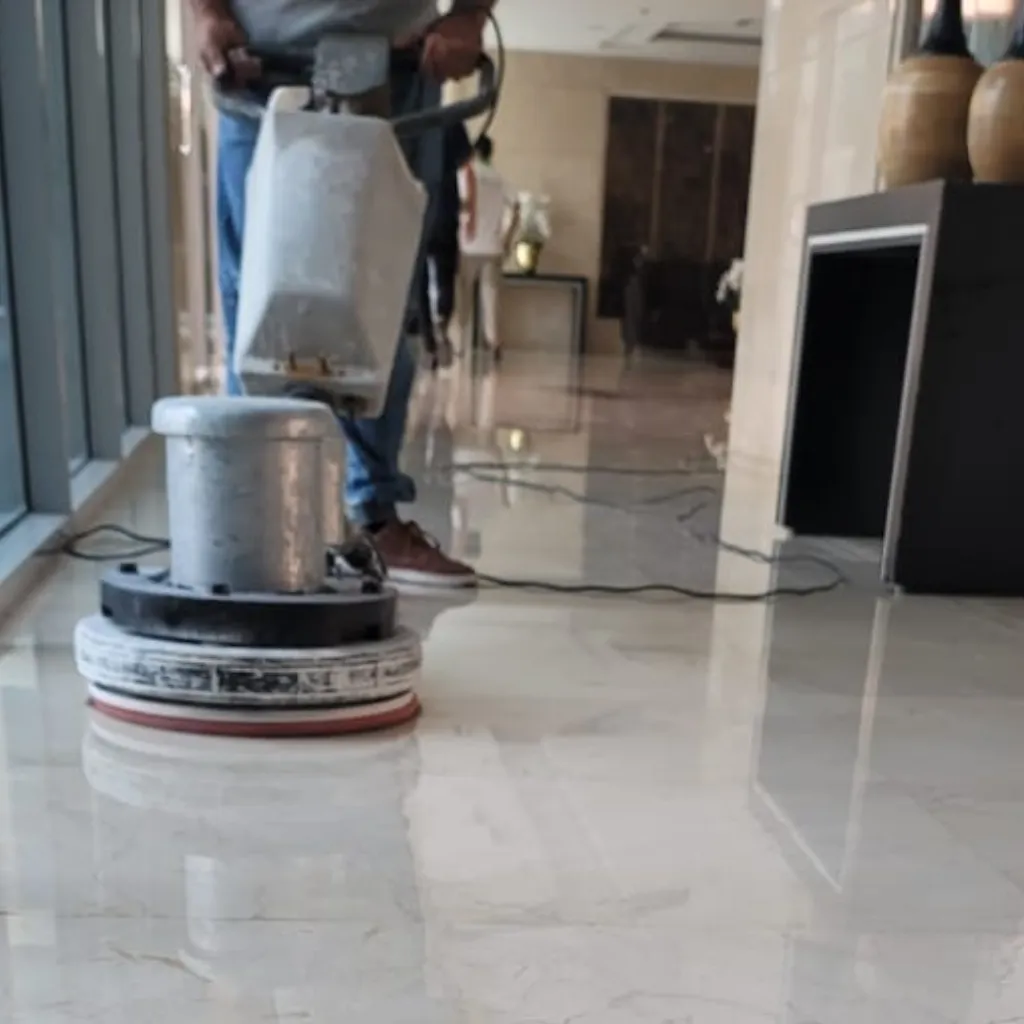 Technician polishing a marble floor with a diamond-pad machine in Dubai